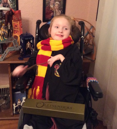 Caitlin Thomas in a wheelchair, wrapped in a Hogwarts scarf