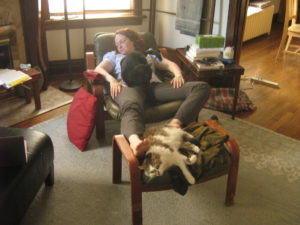 Mary in an armchair with two cats on her