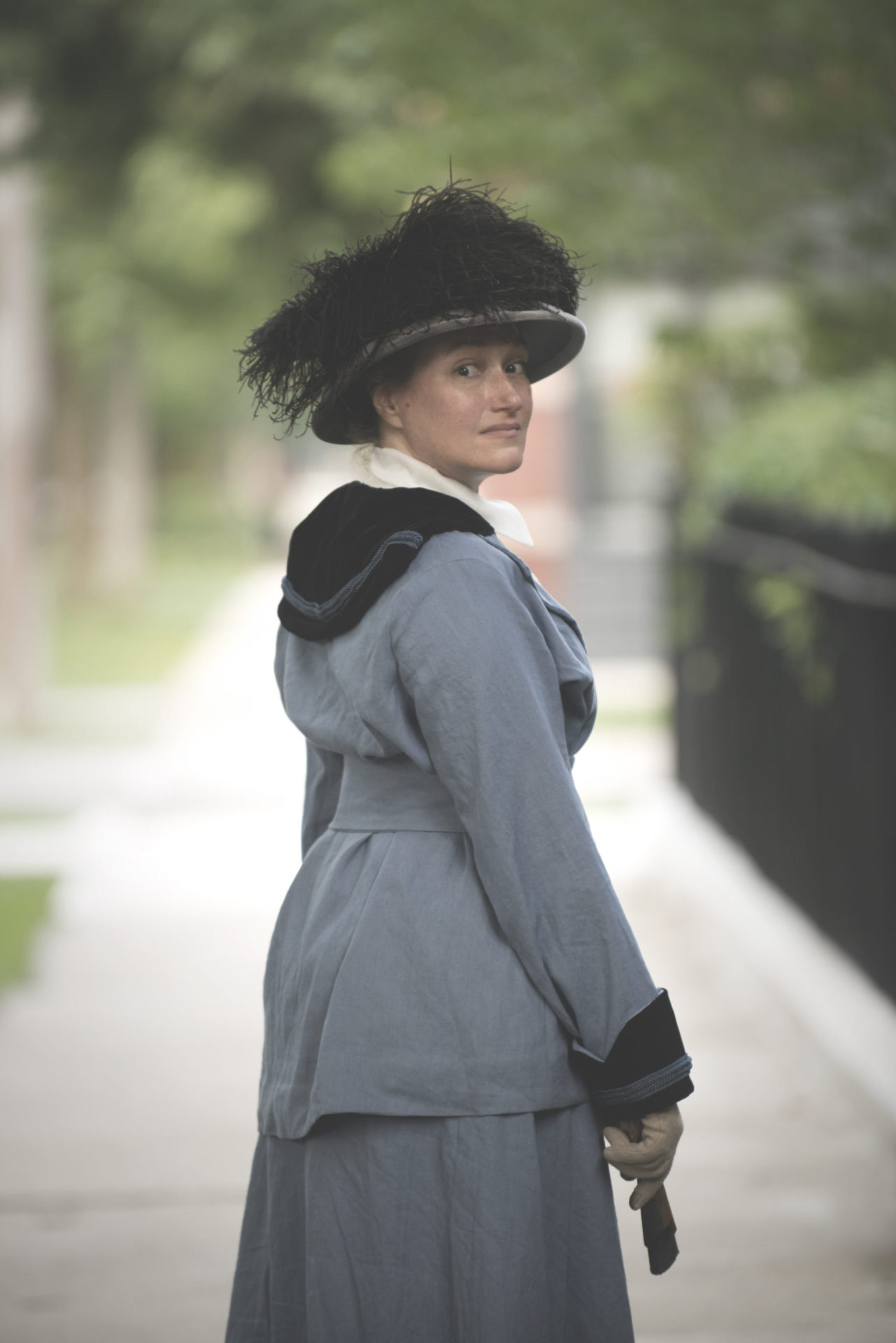 MRK in a replica of the Spirit Corps uniform from Ghost Talkers. Blue, with black velvet collar and a broad brimmed hat, trimmed with black ostrich feathers.