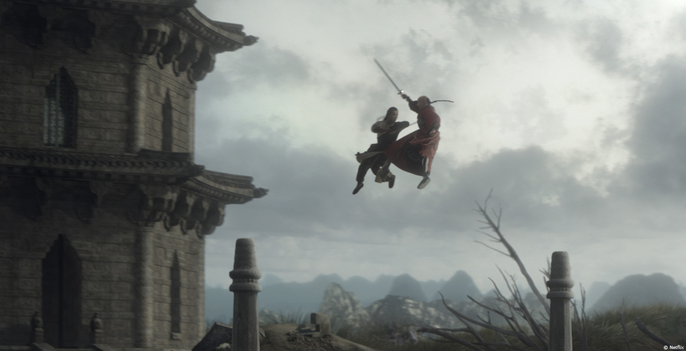 A still from a kung fu movie with two men in the air with swords